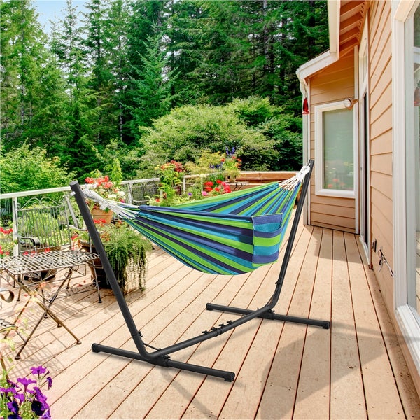 Gestreifte Hängematte mit Gestell auf einer Holzterrasse vor einem Haus