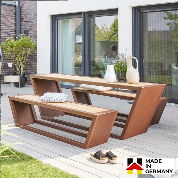 Moderne Garten-Sitzgruppe mit hohem Tisch und Bänken aus Metall in Rost-Optik und Holzlatten auf einer Terrasse. Hergestellt in Deutschland.