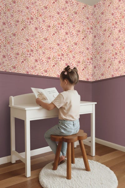 Vliestapete mit Blumenmuster in einem Kinderzimmer über einer lila Wandfläche mit weißem Schreibtisch und Holzschemel.