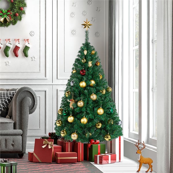 Geschmückter Weihnachtsbaum mit Geschenken in einem hellen Wohnzimmer.