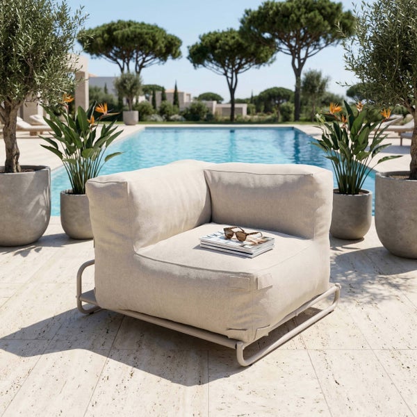 Moderner Garten-Lounge-Sessel in Beige auf einer Steinterrasse neben einem Pool mit mediterraner Bepflanzung.