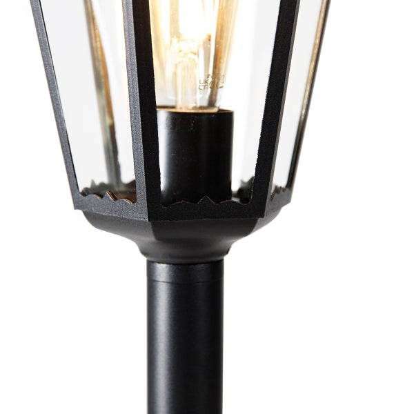 Nahaufnahme einer schwarzen Außenlaterne mit klarem Glas und brennendem Filament-Leuchtmittel.