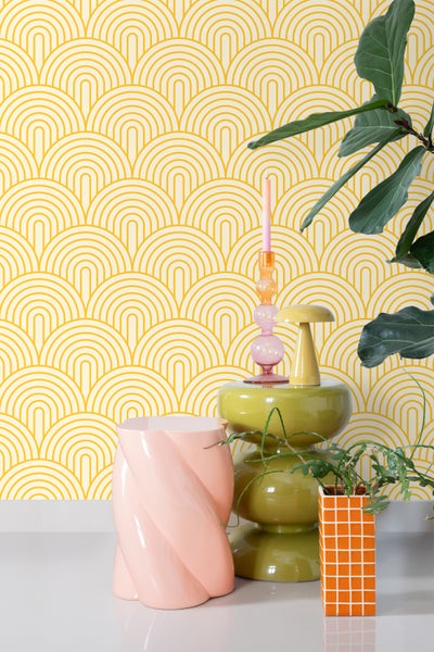 Raumansicht mit gemusterten Tapeten, Beistelltisch und Dekoration