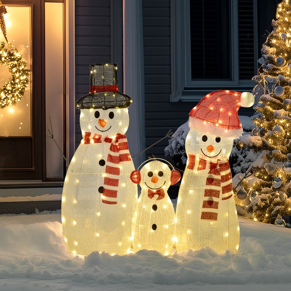 Drei LED-beleuchtete Schneemann-Figuren in verschiedenen Größen für den Außenbereich, dekoriert mit Hüten und Schals, platziert im Schnee.