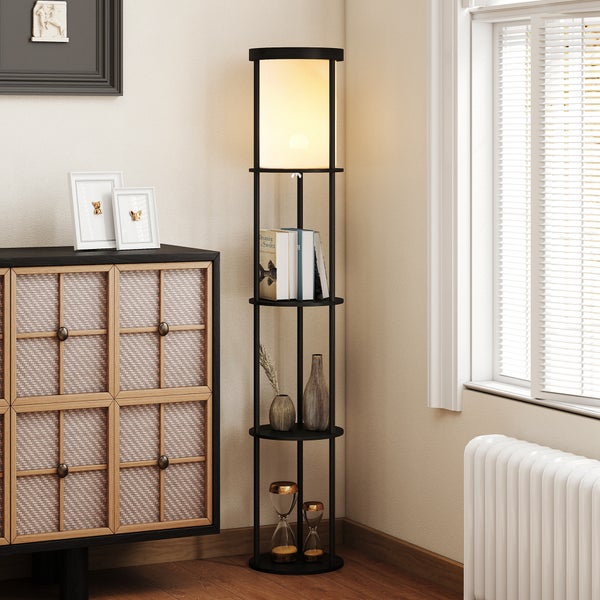 Moderne schwarze Stehleuchte mit integrierten runden Regalfächern in einem hellen Wohnzimmer. Die Lampe hat einen zylindrischen Schirm.