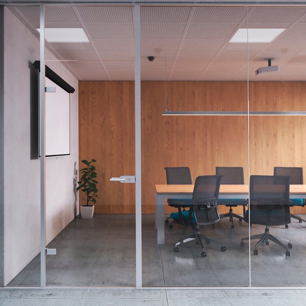 Moderner Konferenzraum mit Glastrennwand, Holzwandverkleidung, Konferenztisch und Bürostühlen in einer hellen und professionellen Büroumgebung.