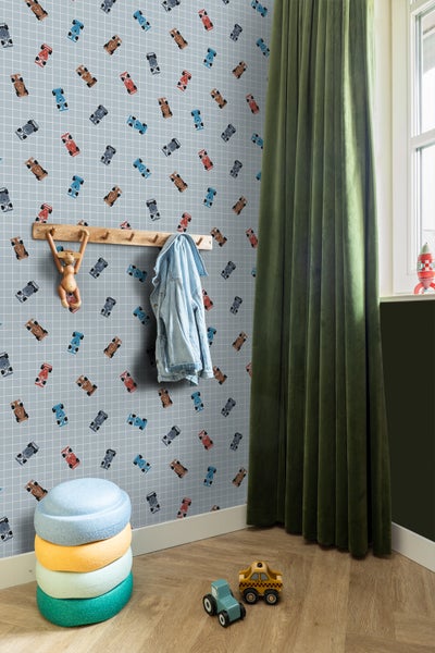 Kinderzimmer mit Auto-Tapete, Holzgarderobe, grünen Vorhängen und Spielzeugautos