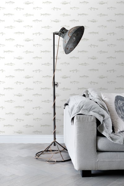 Wohnzimmer mit Tapete mit Fischmuster, Stehlampe und Sofa.