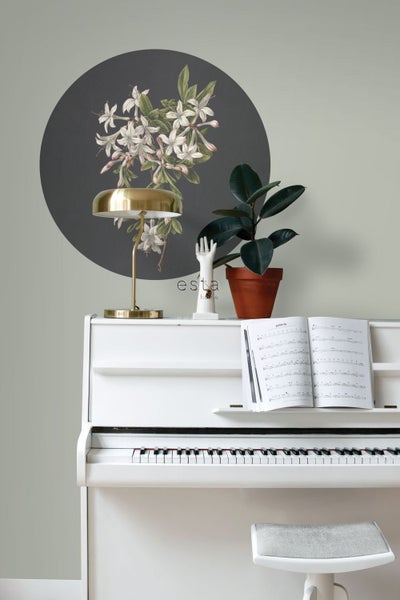 Dekorative Wandgestaltung mit Blumenmotiv über einem weißen Klavier.