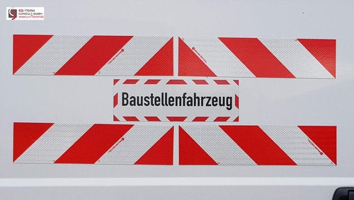 Zwei graue Rattansessel mit hellen Kissen.