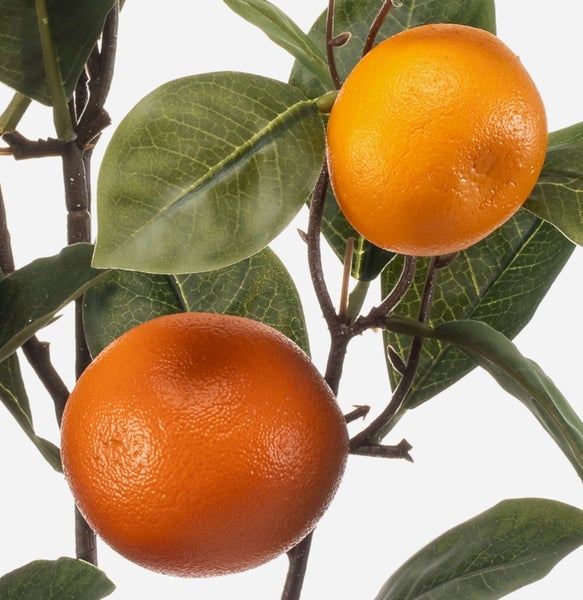 Detailaufnahme eines künstlichen Orangenzweigs mit Früchten und grünen Blättern für die Dekoration.