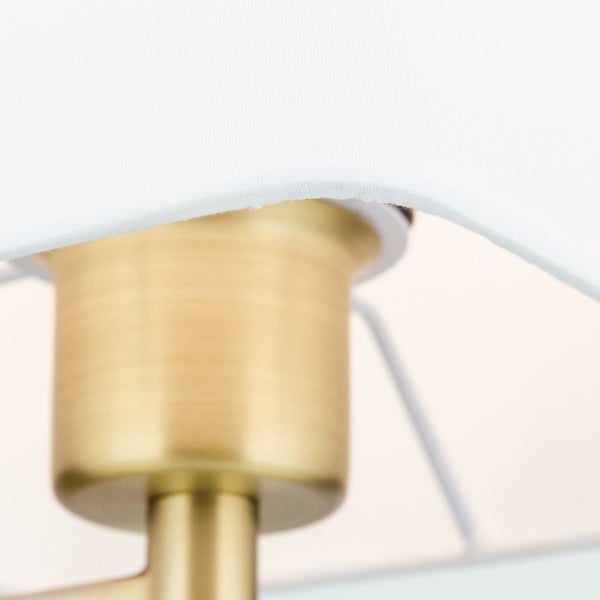 Detailaufnahme einer Lampe mit weißem Lampenschirm und goldenem Lampenfuß.