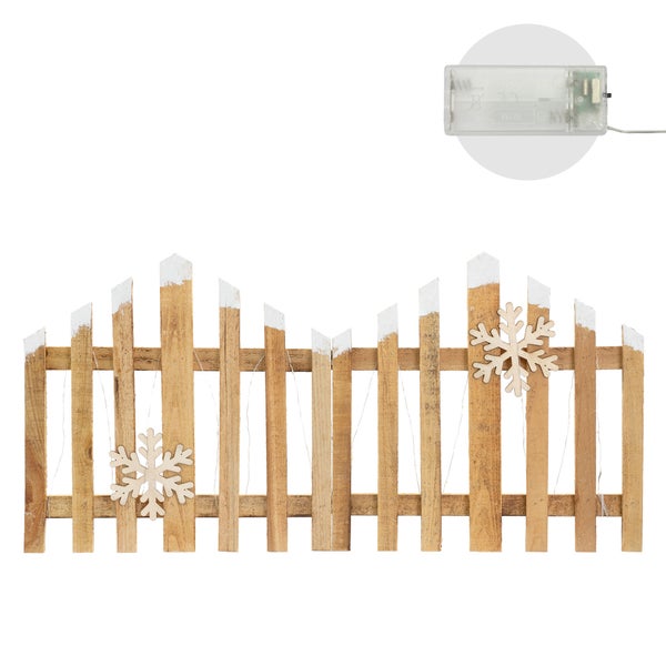 Dekorativer Holzzaun mit Schneeflocken und Lichterkette