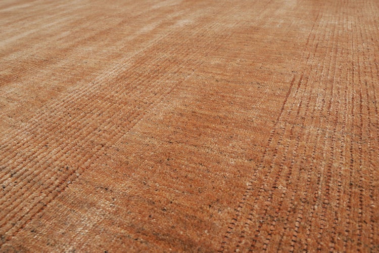 Teppich mit geometrischem Rautenmuster, strukturierter Oberfläche und sichtbarer Rückseite auf Holzboden.