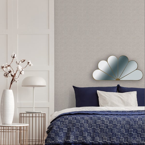 Schlafzimmer mit Bett, Nachttischen, Lampe, Vase mit Baumwollzweigen und Spiegel in Blütenform