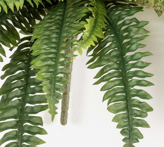 Nahaufnahme von künstlichen grünen Farnwedeln aus Kunststoff.