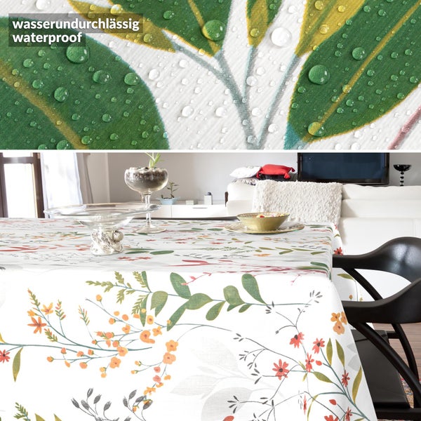 Wasserundurchlässige Tischdecke mit Blattmuster und Blüten in einem hellen Zimmer, Detailansicht der wasserabweisenden Materialoberfläche.