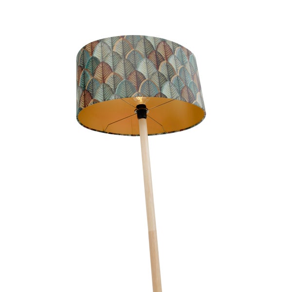 Stehleuchte mit einem Lampenschirm mit Blattmuster und einem schlichten Holzständer