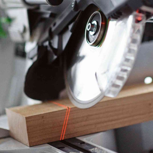 Kapp- und Gehrungssäge schneidet ein Holzstück mit Laserführung