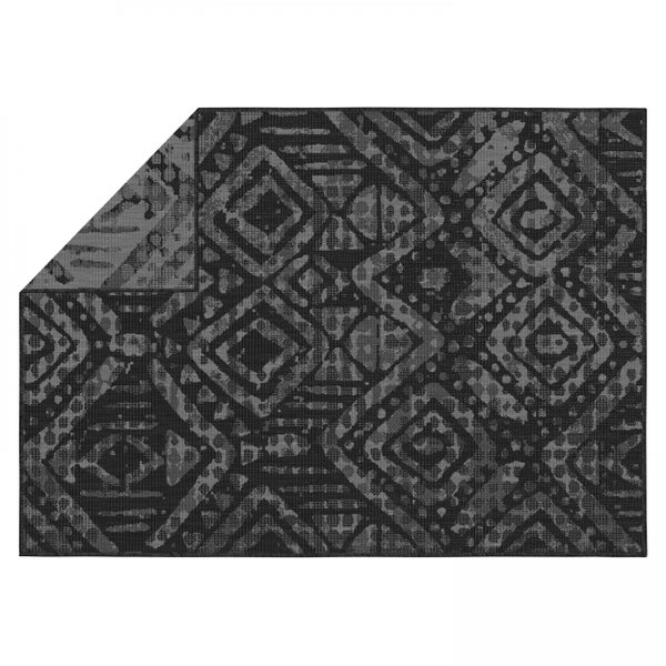 Teppich mit geometrischem Rautenmuster in Grau, eine Ecke umgeschlagen.