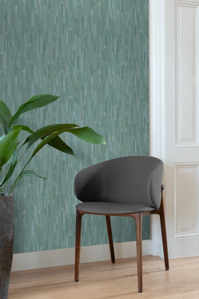 Raumansicht mit grafischer Tapete, Stuhl und Pflanze