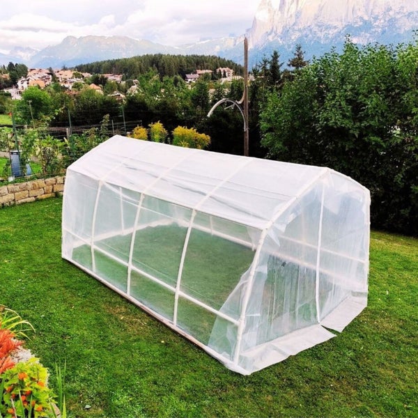 Gewächshaus auf Rasen vor Berglandschaft