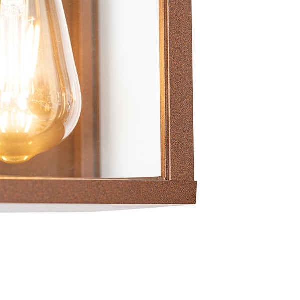 Detailansicht einer rostfarbenen Wandleuchte aus Metall mit Glaseinsatz und leuchtendem LED-Filament-Leuchtmittel.