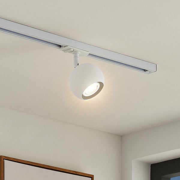 Weißer, kugelförmiger Strahler montiert an einem Schienensystem an der Decke, eingeschaltet.