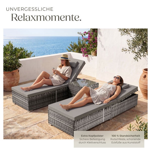 Zwei graue Polyrattan-Gartenliegen mit Auflagen, Kopfpolstern und Beistelltisch auf einer Terrasse mit Meerblick.