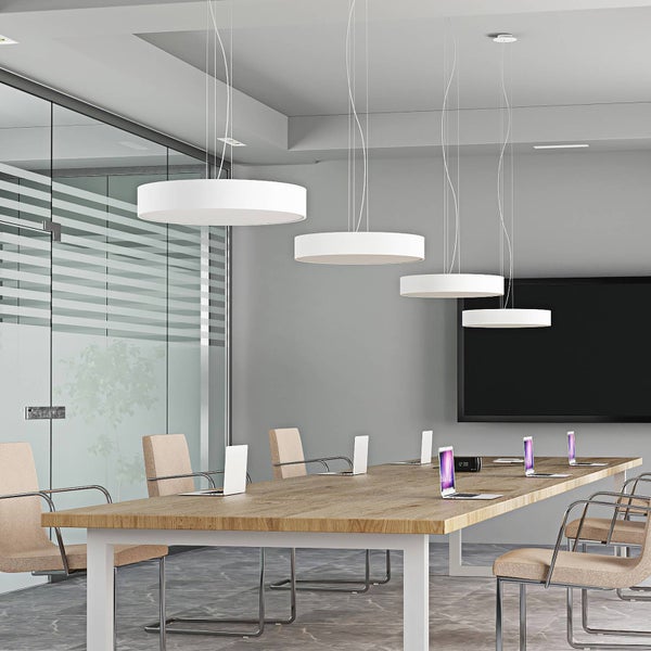 Moderner Konferenzraum mit großem Holztisch, Stoffstühlen und vier runden, flachen Pendelleuchten in Weiß.