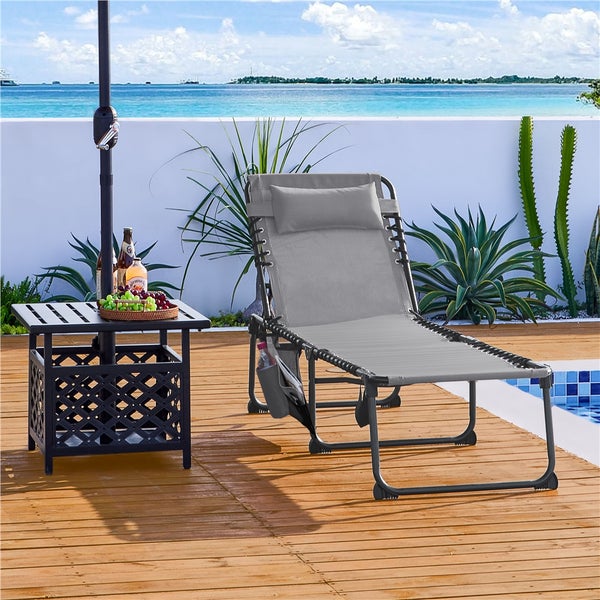 Szene mit einer grauen Sonnenliege, einem kleinen Tisch und Getränken im Freien