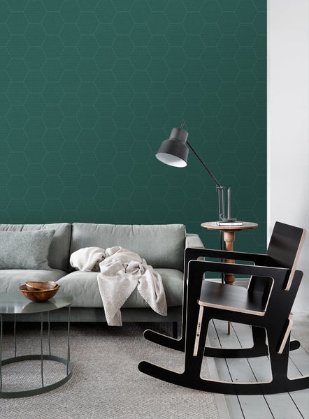 Wohnzimmer mit Sofa, Tisch, Lampe und Wandtapete mit geometrischem Muster