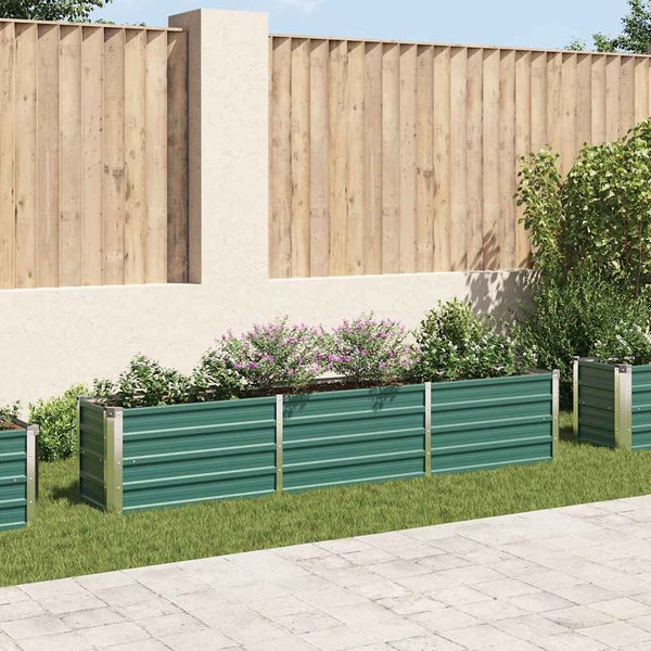 Rechteckiges Hochbeet aus Metall mit gerippter Struktur in einem Garten mit Holzzaun und Pflanzen.