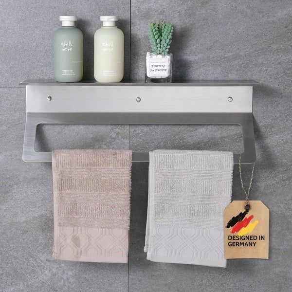 Edelstahl-Badezimmerregal mit Handtuchhalter an einer Fliesenwand, dekoriert mit Badutensilien und Handtüchern, in Deutschland entworfen.