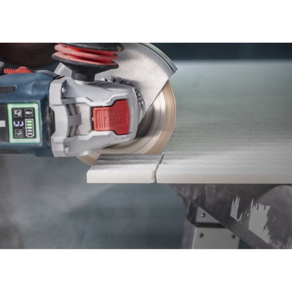 Akkubetriebener Winkelschleifer beim Schneiden einer Fliese.