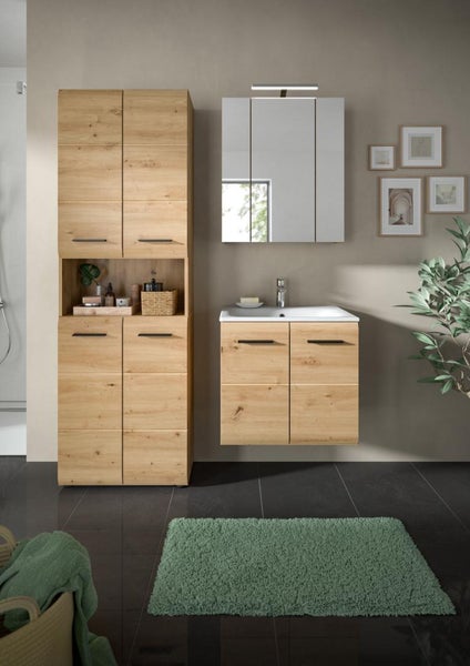 Badezimmermöbel-Set in Eiche-Optik mit Hochschrank, Waschtischunterschrank mit Waschbecken und Spiegelschrank in einem hellen Badezimmer.