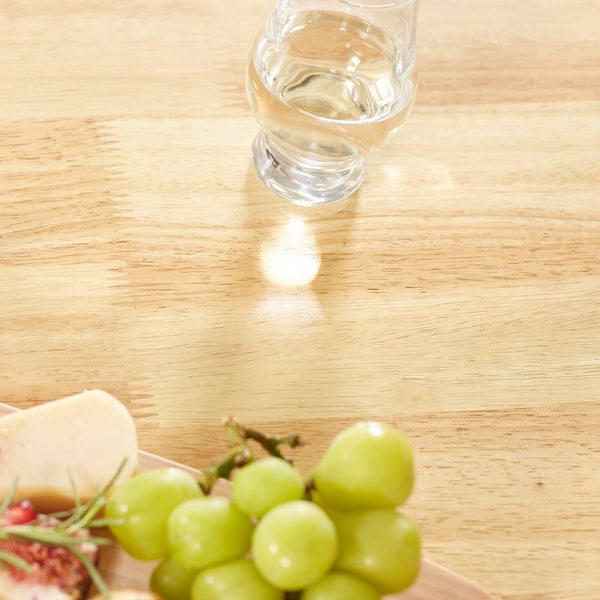 Stillleben mit Glas Wasser, Käse und Trauben auf einem Holztisch