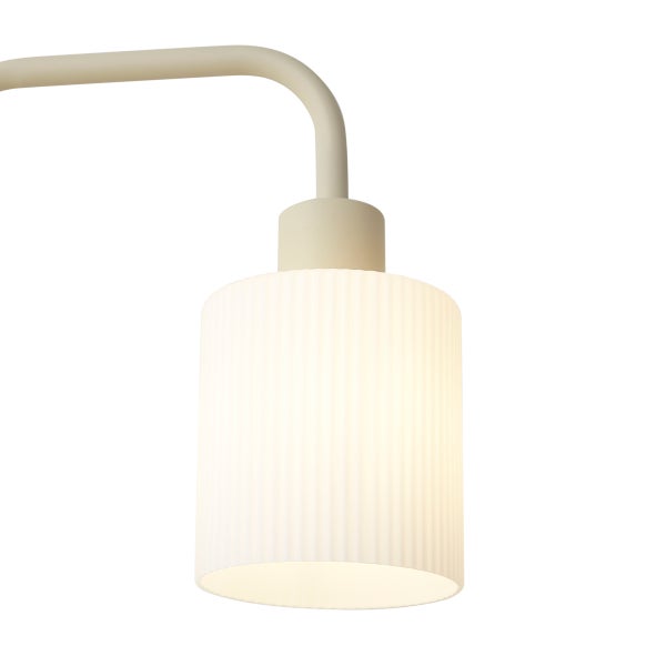 Wandleuchte mit geriffeltem Glaszylinder und beigem Metallarm.