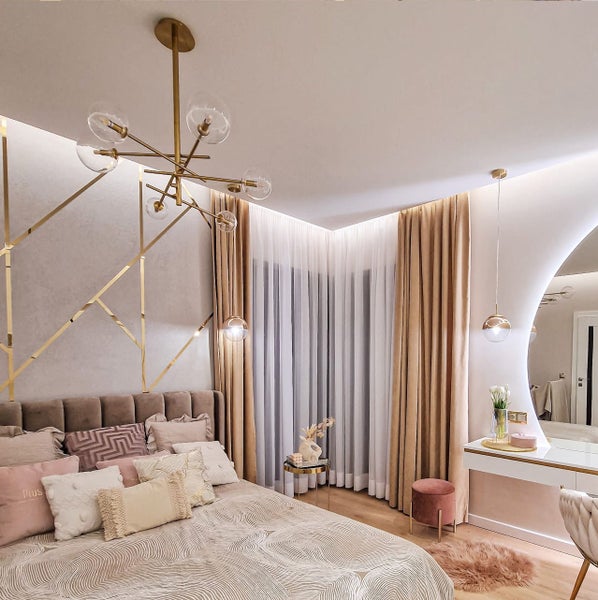 Schlafzimmer mit Bett, Vorhängen, Beleuchtung und Schminktisch