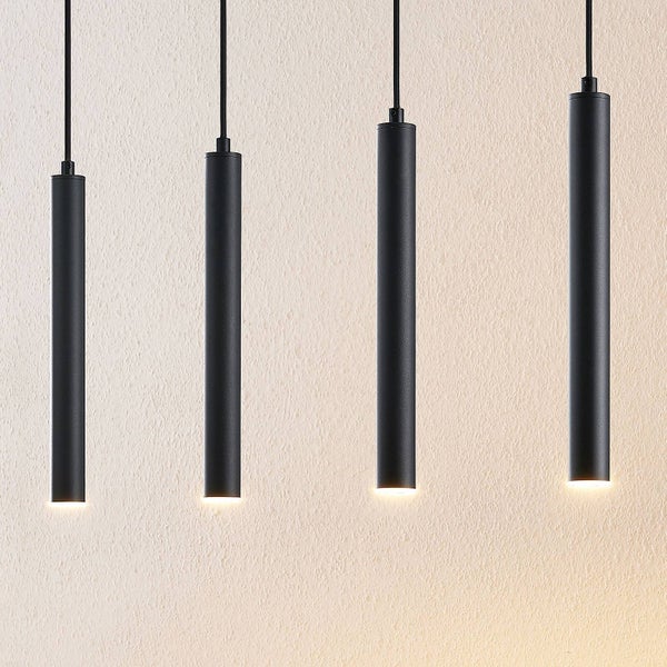 Vier schlanke schwarze zylindrische Pendelleuchten in verschiedenen Höhen mit nach unten gerichtetem Licht.