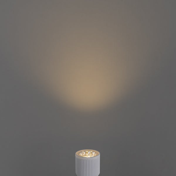 Zylindrischer LED-Strahler mit geriffelter Struktur strahlt warmes Licht kegelförmig nach oben.