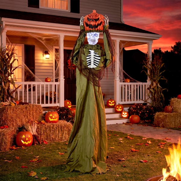 Animierte Halloween Skelett Figur mit Kürbis Kopf in einem herbstlich dekorierten Vorgarten.