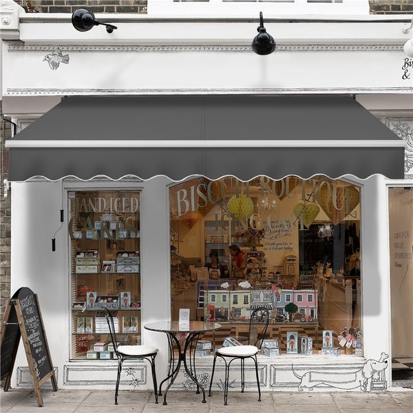 Fassade eines Ladens mit Markise und Tisch mit Stühlen davor