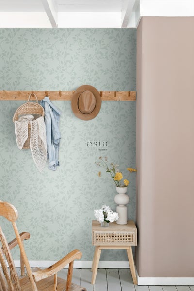 Dekoratives Zimmer mit gemusterter Tapete, Hocker, Jacke und Hut