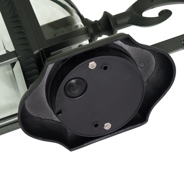 Unterseite einer schwarzen Außenleuchte mit Montageplatte und Sensor.