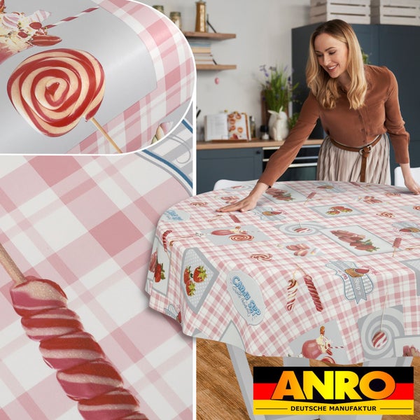 Rundes Tischtuch mit rosa-weißem Karomuster, Süßigkeiten- und Erdbeermotiven, auf einem Tisch in einer Küche. ANRO Logo.