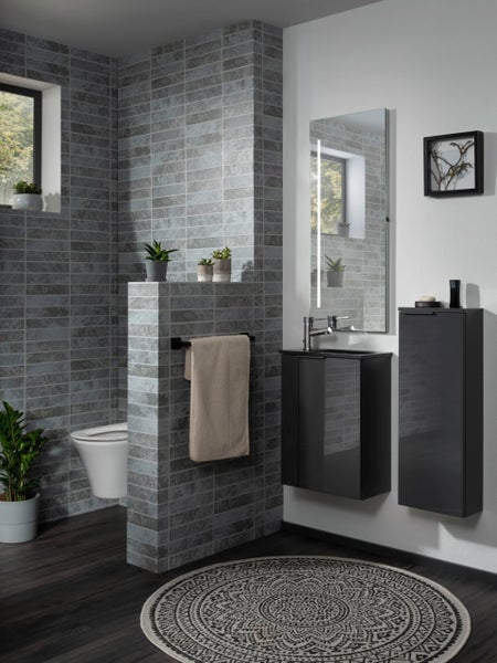 Helles Badezimmer mit Waschtisch, Spiegel, Toilette und gemustertem Teppich