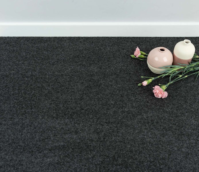 Dunkelgrauer, strukturierter Teppichboden oder Bodenmatte mit dekorativen Vasen und Blumen.