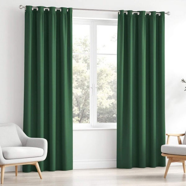 Grüne Gardinen vor einem Fenster mit zwei Sesseln