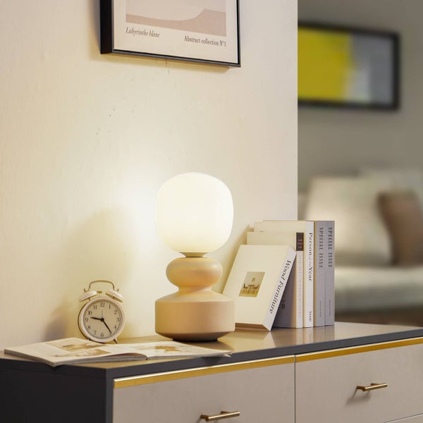 Szene mit Nachttischlampe, Tischuhr und Büchern auf einer Kommode